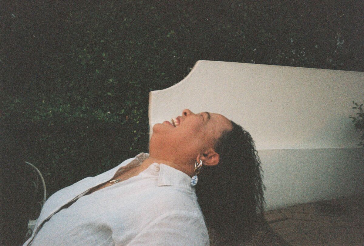 A guest leaning back on a white bench, laughing