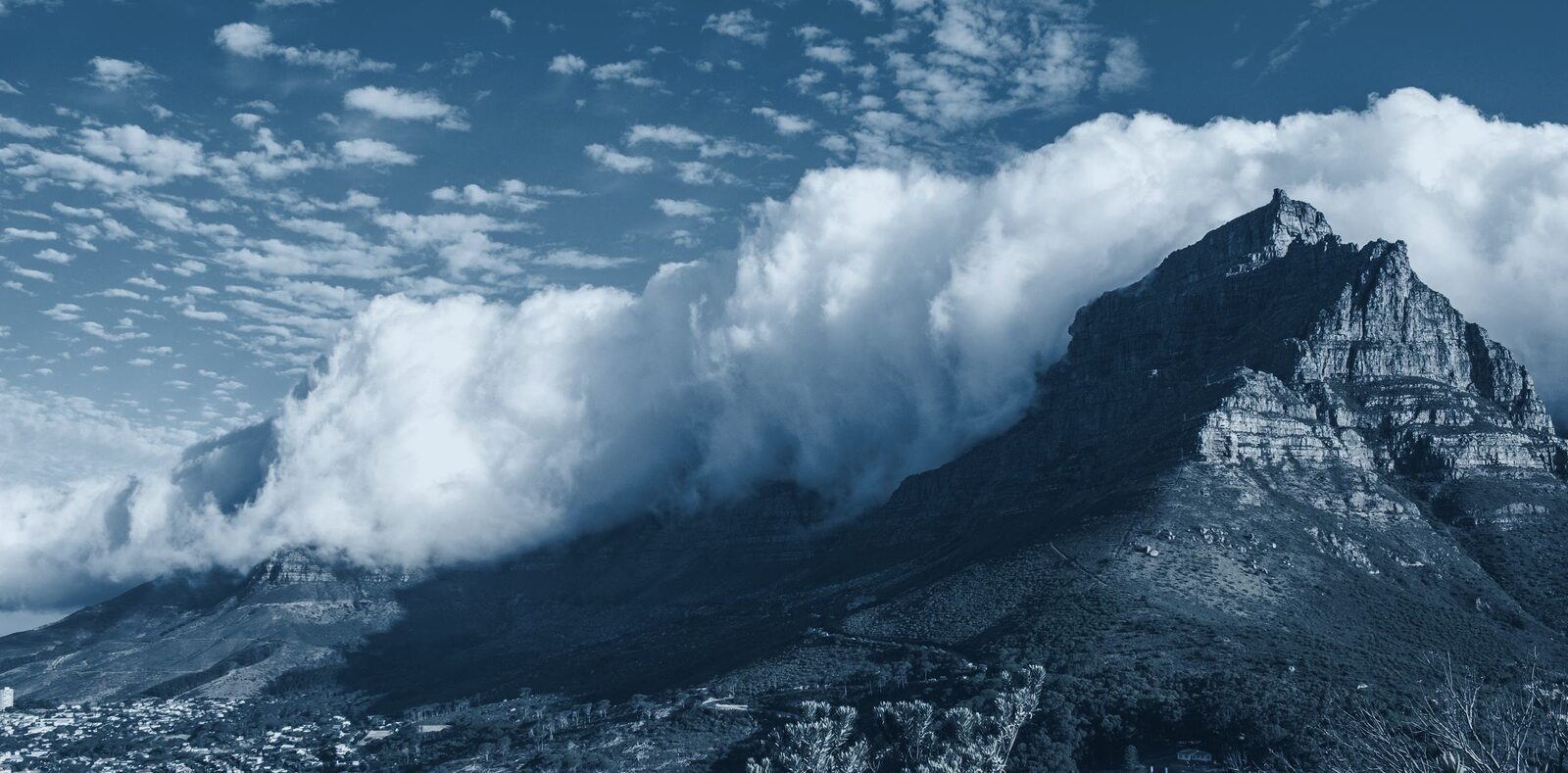 Duotone photograph of the tablecloth cloud pouring over Table Mountain