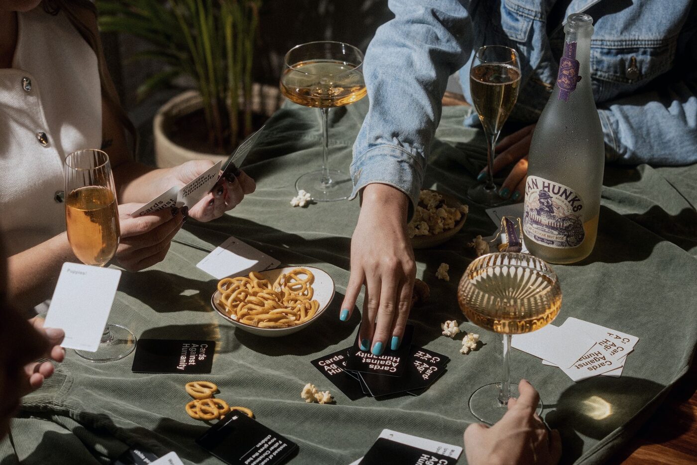 Friends around an outdoor table with Van Hunks sparkling wine and snacks